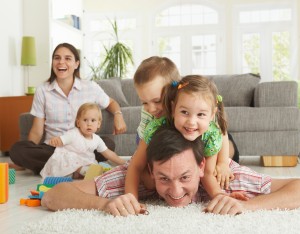 Happy family having fun on floor of in living room at home, laug